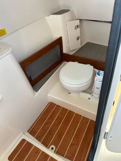  Yacht Photos Pics 2024 Grady-White Freedom 285 boat bathroom with wooden flooring and compact toilet.