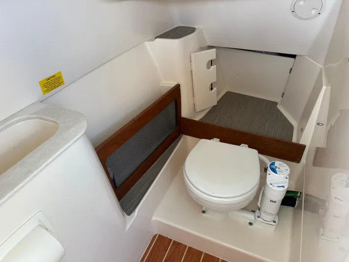  Yacht Photos Pics 2024 Grady-White Freedom 285 boat interior with toilet and storage area.