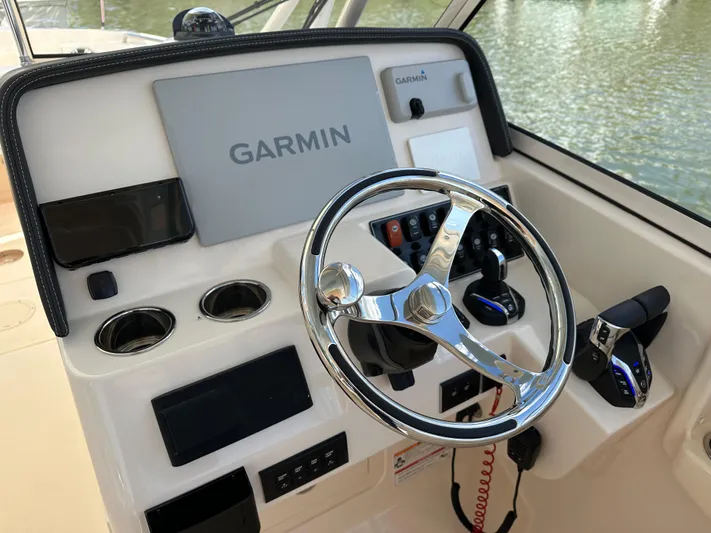  Yacht Photos Pics 2024 Grady-White Freedom 285 boat dashboard with Garmin navigation system and steering wheel.