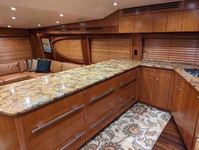 Yacht Photos Pics Luxurious interior of 2007 Hatteras 68 Convertible yacht with granite countertops and wooden cabinetry.