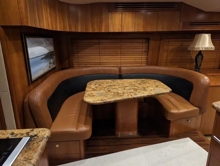  Yacht Photos Pics Luxurious dining area in a 2007 Hatteras 68 Convertible yacht with granite table and leather seating.