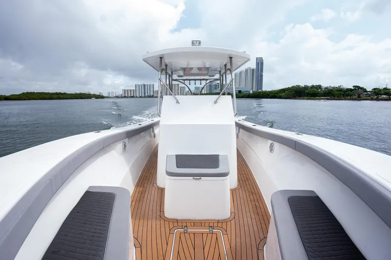  Yacht Photos Pics 2023 Seahorse 36 CC boat cruising on a calm waterway, modern design, cityscape background.