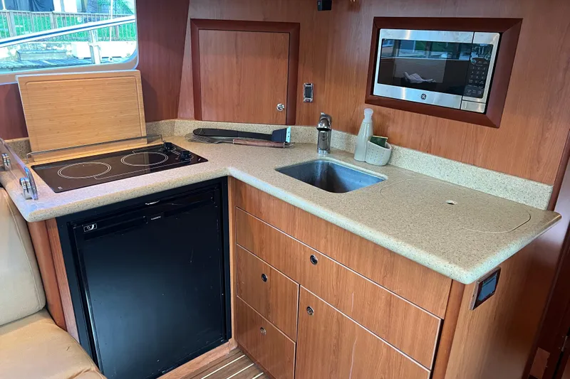  Yacht Photos Pics 2008 Luhrs 35 Convertible yacht kitchen with stove, sink, microwave, and compact fridge.