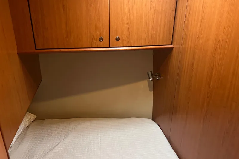  Yacht Photos Pics 2008 Luhrs 35 Convertible cabin interior with wooden cabinets and a cozy bed.