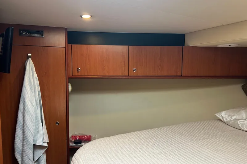  Yacht Photos Pics 2008 Luhrs 35 Convertible cabin interior with wood cabinets and bed.