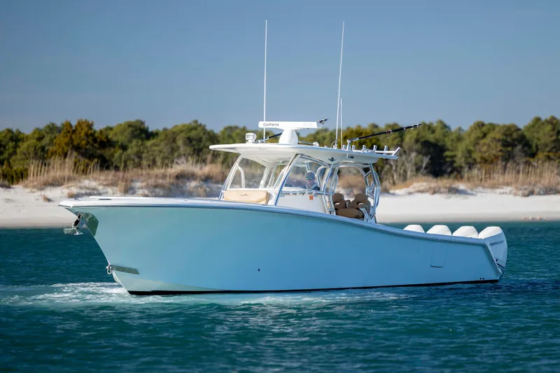  Yacht Photos Pics 2020 Blackwater 41 Tournament boat cruising on clear blue water near a sandy shoreline.