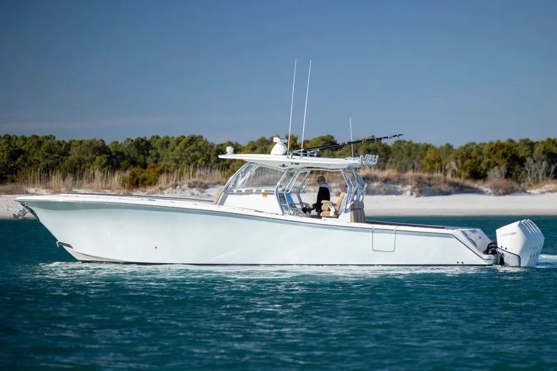  Yacht Photos Pics 2020 Blackwater 41 Tournament boat cruising on blue water near a sandy shoreline.