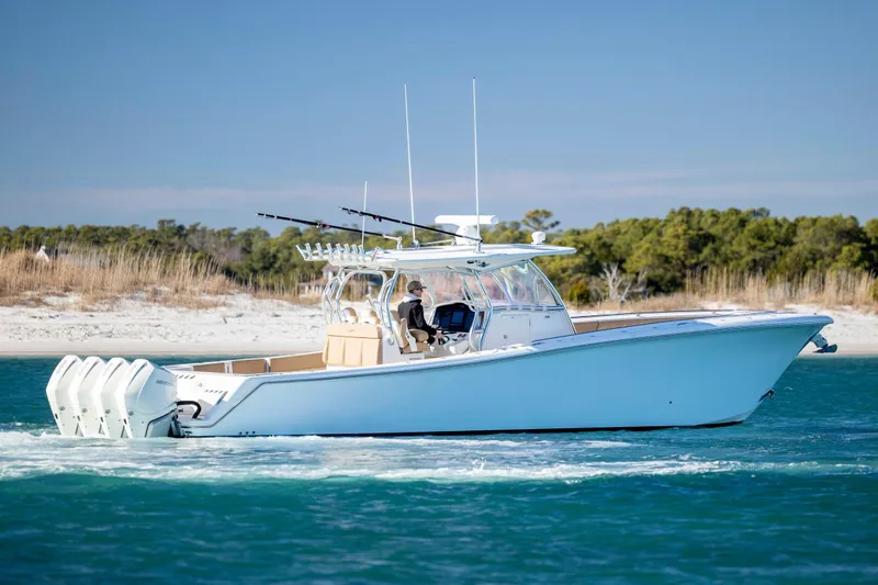  Yacht Photos Pics 2020 Blackwater 41 Tournament boat cruising on blue water near sandy shoreline.