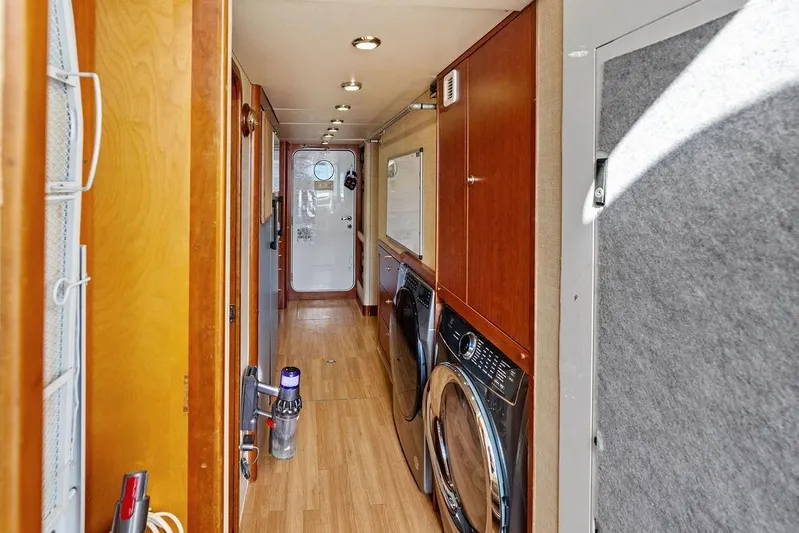 Picosa Lady Yacht Photos Pics Hallway of 2001 West Bay 103 Sonship yacht with laundry appliances and wooden flooring.