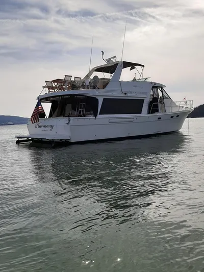 "harmony" Yacht Photos Pics 1995 Bayliner 4788 Pilot House Motoryacht on calm water under cloudy sky.