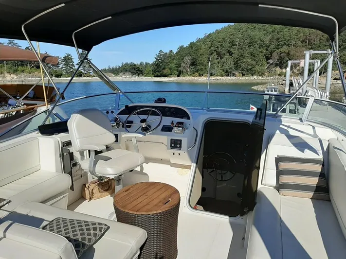 "harmony" Yacht Photos Pics 1995 Bayliner 4788 Pilot House Motoryacht interior with helm, seating, and scenic water view.