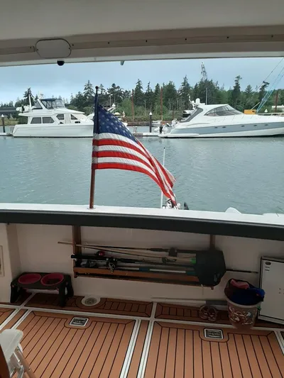 "harmony" Yacht Photos Pics 1995 Bayliner 4788 Pilot House Motoryacht with American flag, docked in a marina.