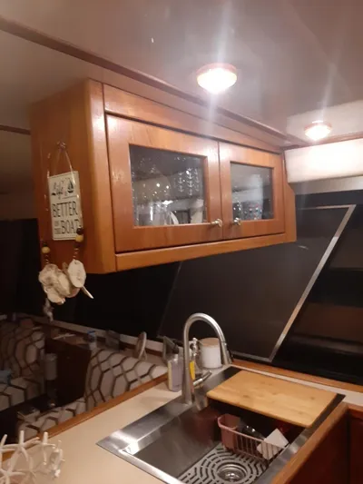 "harmony" Yacht Photos Pics Interior of 1995 Bayliner 4788 Pilot House Motoryacht kitchen with wooden cabinets and sink.