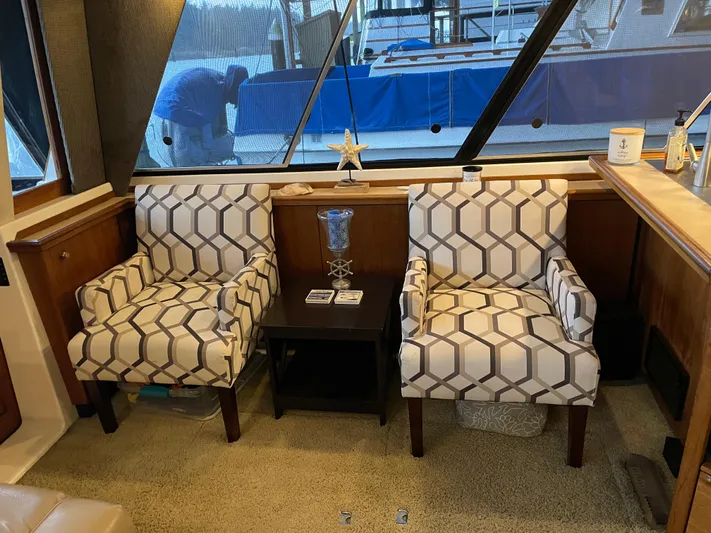 "harmony" Yacht Photos Pics Interior of 1995 Bayliner 4788 Pilot House Motoryacht with patterned chairs and table.