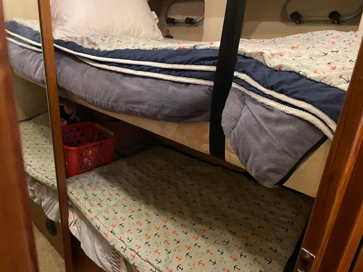 "harmony" Yacht Photos Pics Bunk beds in 1995 Bayliner 4788 Pilot House Motoryacht cabin with nautical-themed bedding.