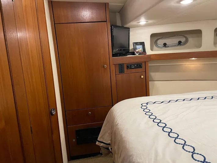"harmony" Yacht Photos Pics 1995 Bayliner 4788 Pilot House Motoryacht interior with wood cabinetry and cozy bedroom.