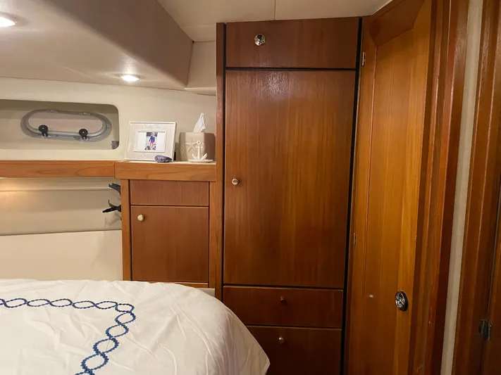 "harmony" Yacht Photos Pics Cozy cabin interior of 1995 Bayliner 4788 Pilot House Motoryacht with wooden cabinetry and bed.