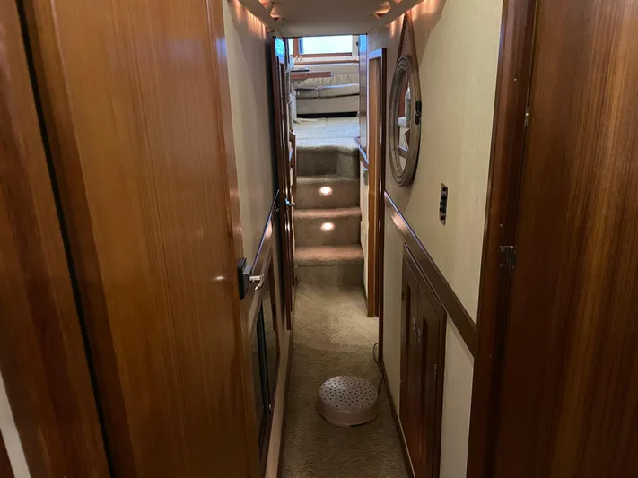 "harmony" Yacht Photos Pics Hallway inside 1995 Bayliner 4788 Pilot House Motoryacht, featuring wooden paneling and carpeted stairs.