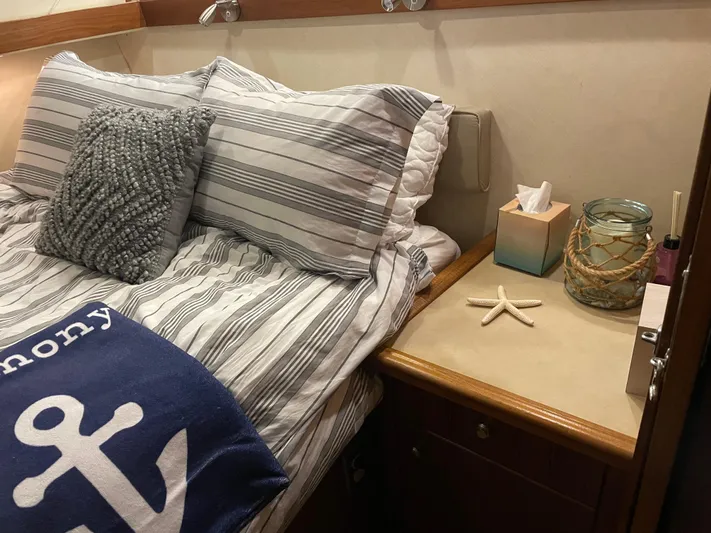 "harmony" Yacht Photos Pics Cozy bedroom in 1995 Bayliner 4788 Pilot House Motoryacht with nautical decor and striped bedding.