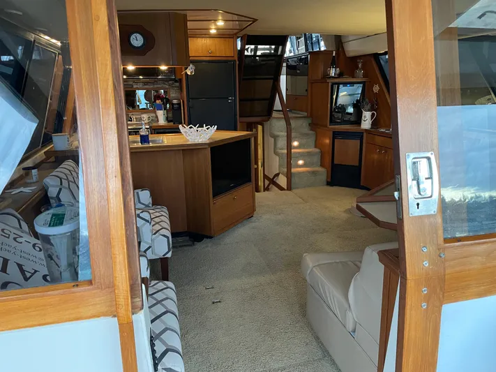 "harmony" Yacht Photos Pics Interior of 1995 Bayliner 4788 Pilot House Motoryacht, featuring cozy seating and wooden cabinetry.