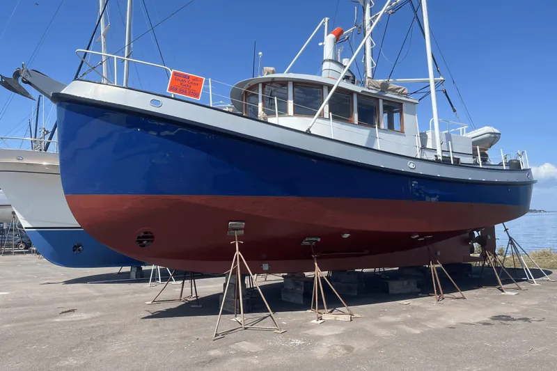 " Loon Point " Yacht Photos Pics 1986 Custom 48 Trawler on dry dock, blue and red hull, clear sky background.