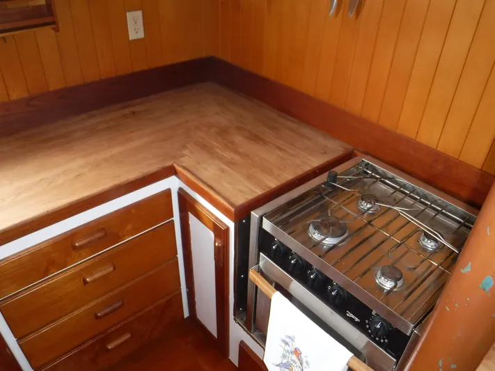 " Loon Point " Yacht Photos Pics Wooden kitchen interior with stove and drawers on a 1986 Custom 48 Trawler boat.