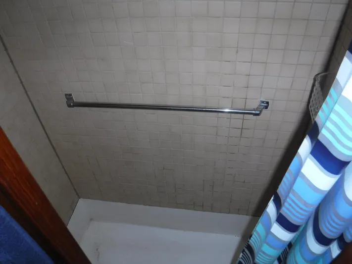 " Loon Point " Yacht Photos Pics Shower area with tiled wall and striped curtain on 1986 Custom 48 Trawler.