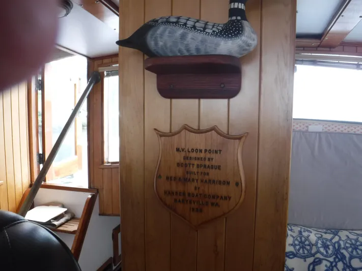 " Loon Point " Yacht Photos Pics Wood-paneled interior of 1986 Custom 48 Trawler with decorative plaque and bird sculpture.