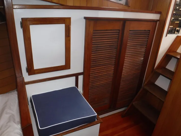 " Loon Point " Yacht Photos Pics Interior of 1986 Custom 48 Trawler with wooden paneling and blue cushioned seat.