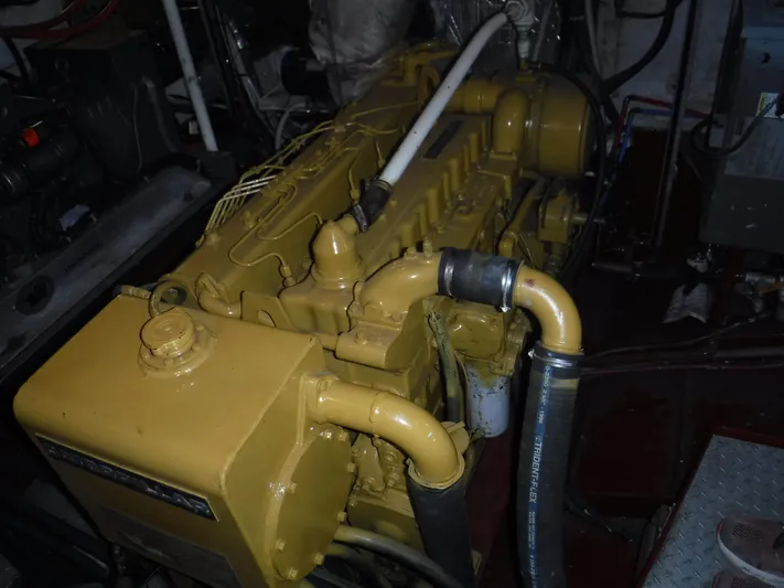 " Loon Point " Yacht Photos Pics Engine room of 1986 Custom 48 Trawler with yellow machinery and hoses.