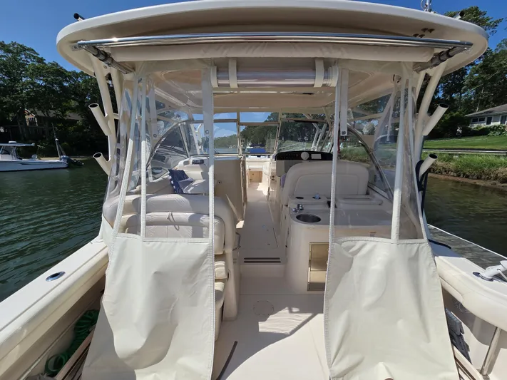  Yacht Photos Pics 2017 Grady-White Freedom 335 boat interior with seating and clear enclosures on a sunny day.