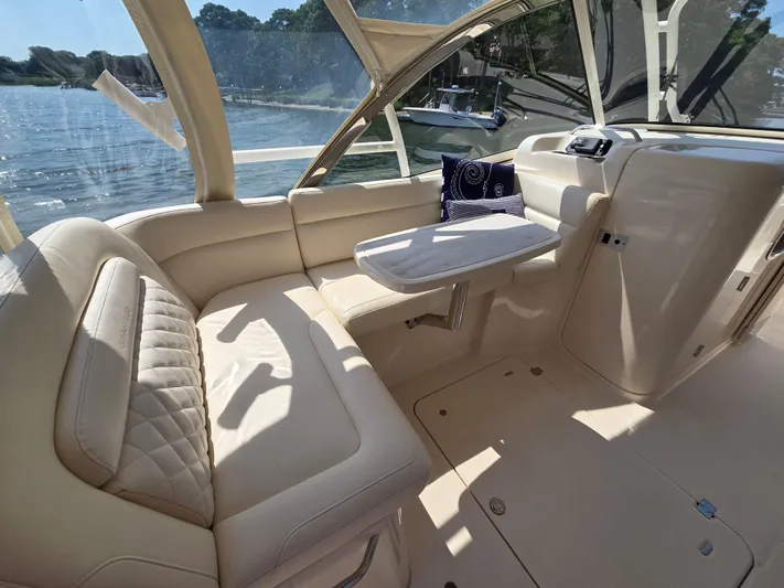  Yacht Photos Pics 2017 Grady-White Freedom 335 boat interior with beige seating and table, overlooking water.