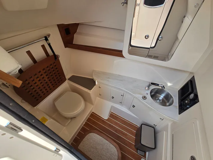  Yacht Photos Pics 2017 Grady-White Freedom 335 boat interior with toilet, sink, and wooden accents.
