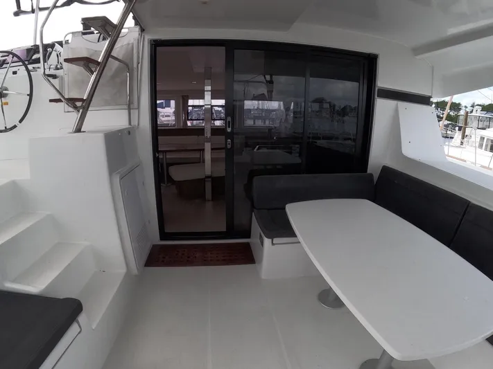 Oceanfront Yacht Photos Pics 2019 Lagoon 42 yacht cockpit with seating and table, featuring modern design and spacious layout.