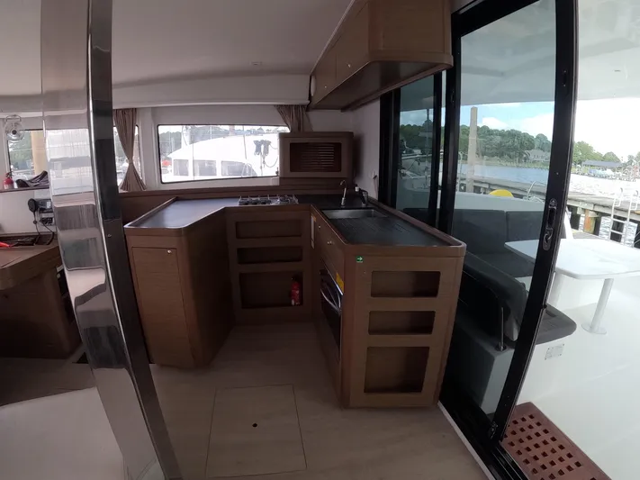 Oceanfront Yacht Photos Pics Interior of a 2019 Lagoon 42 catamaran featuring a modern kitchen and outdoor view.