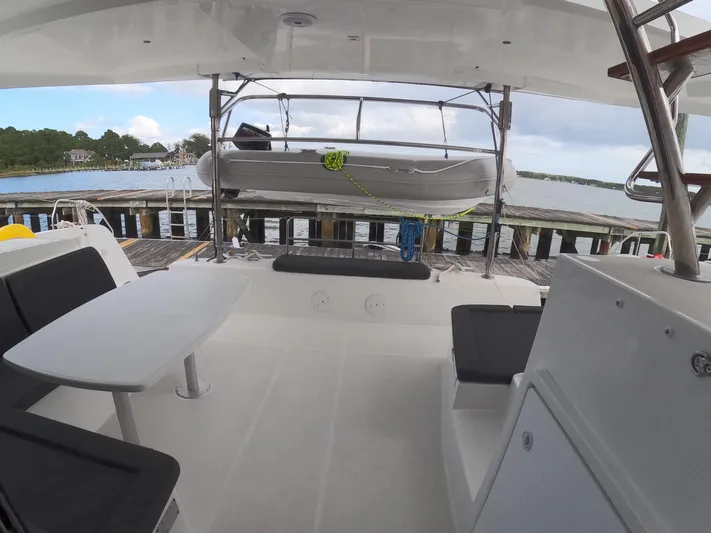 Oceanfront Yacht Photos Pics 2019 Lagoon 42 catamaran deck with seating, table, and docked view.