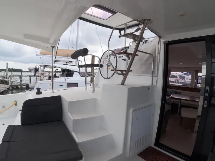 Oceanfront Yacht Photos Pics Interior view of 2019 Lagoon 42 catamaran, featuring helm station and seating area.