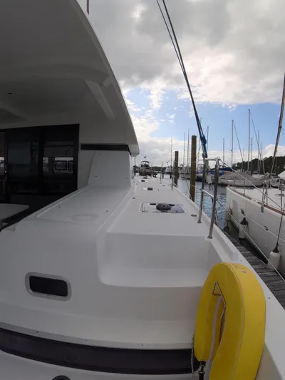 Oceanfront Yacht Photos Pics 2019 Lagoon 42 catamaran docked at marina under cloudy sky.