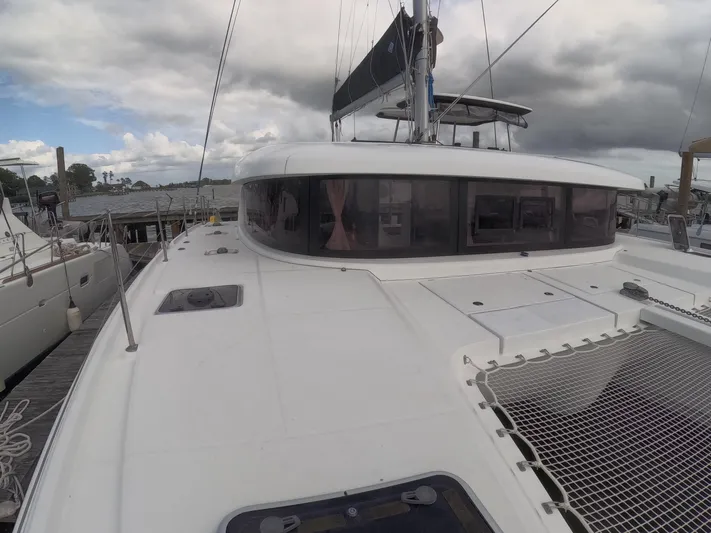 Oceanfront Yacht Photos Pics 2019 Lagoon 42 catamaran docked, featuring sleek design and spacious deck under cloudy skies.