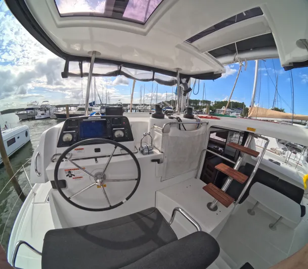 Oceanfront Yacht Photos Pics Cockpit of a 2019 Lagoon 42 catamaran with steering wheel and navigation equipment.