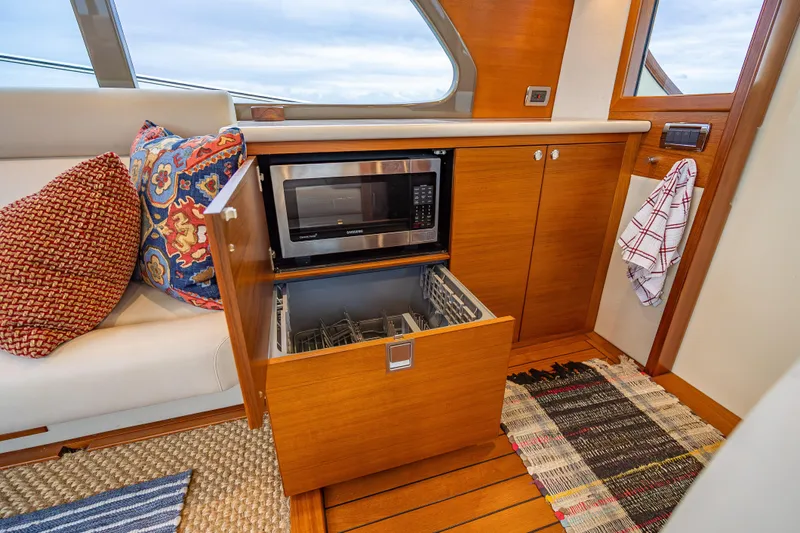 Date Night Yacht Photos Pics Luxurious 2020 Palm Beach Motor Yachts PB50 interior with microwave and dishwasher in wooden cabinetry.