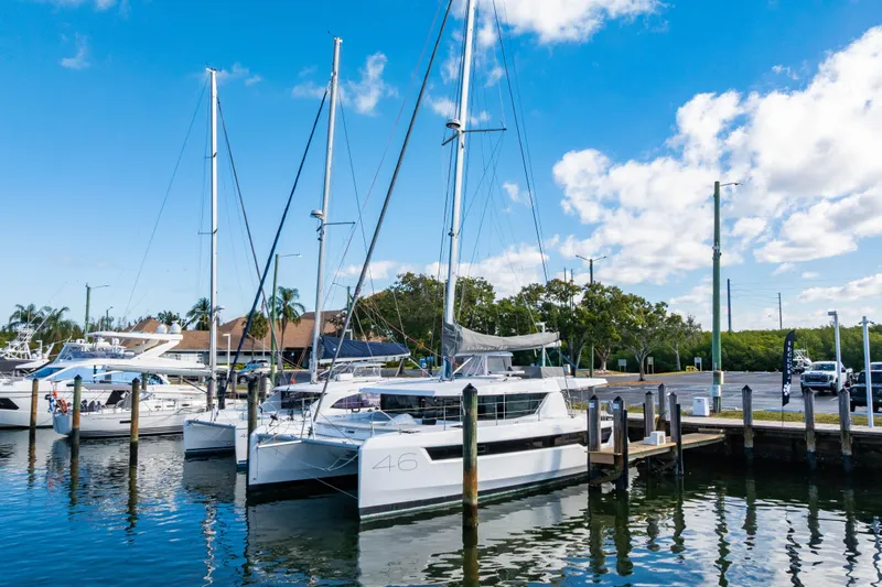 C1022 Yacht Photos Pics 2025 Leopard 46 catamaran docked at marina under blue sky.