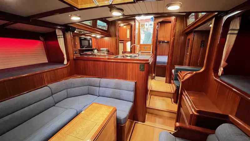 Nala Yacht Photos Pics Luxurious 2004 Lyman-Morse Sparkman & Stephens Sloop interior with wood finish and blue seating.