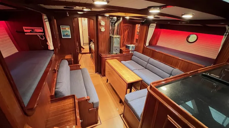 Nala Yacht Photos Pics Luxurious 2004 Lyman-Morse Sparkman & Stephens Sloop interior with wood finish and blue seating.