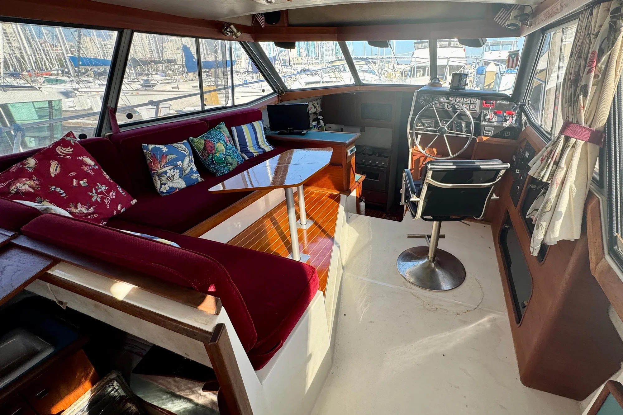 1989 Bayliner 3288 Motoryacht interior with helm, seating, and colorful cushions.
