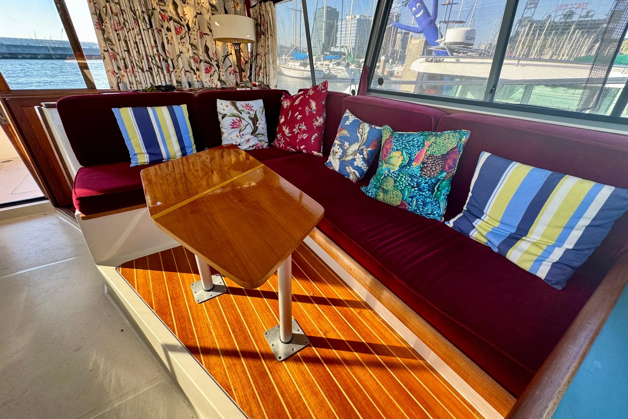 Interior of 1989 Bayliner 3288 Motoryacht with colorful cushions and wooden table.