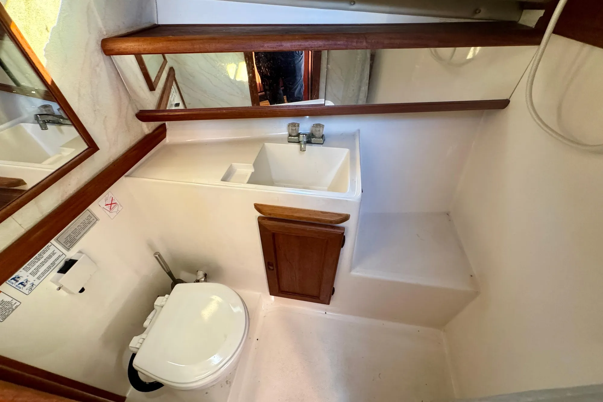 1989 Bayliner 3288 Motoryacht bathroom with sink, toilet, and wooden accents.