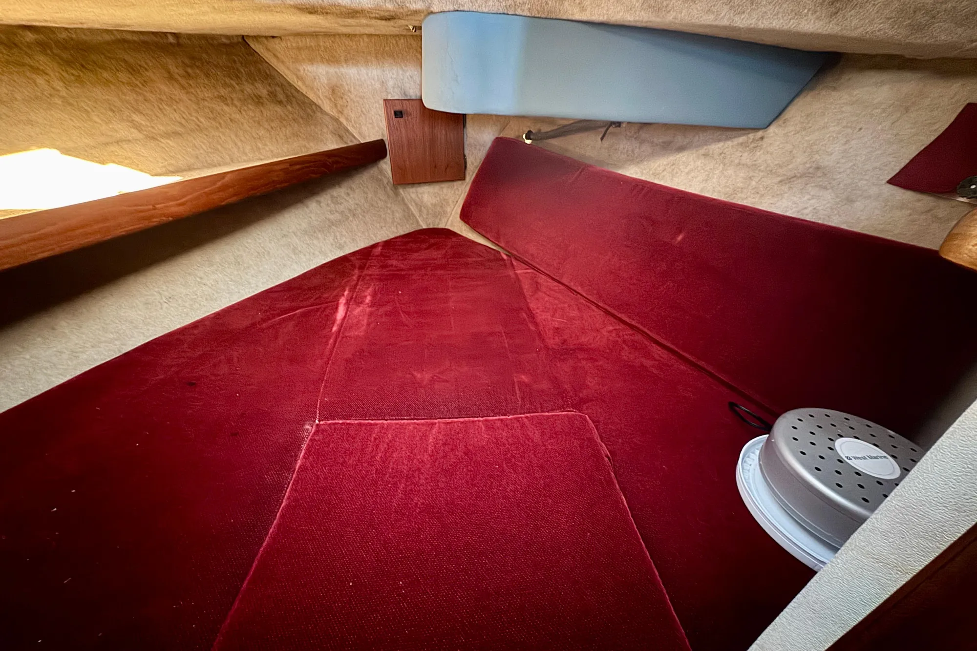 Interior cabin of 1989 Bayliner 3288 Motoryacht with red upholstery and storage space.