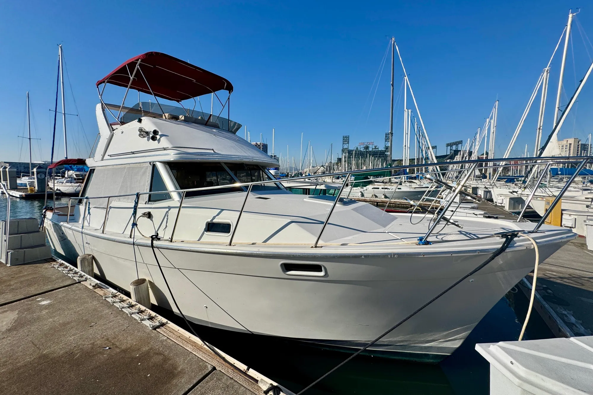 1989 Bayliner 3288 Motoryacht docked at marina under clear blue sky.