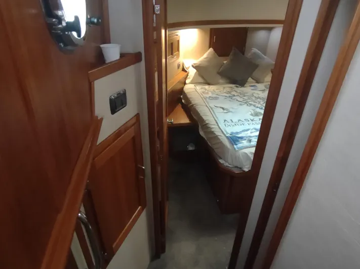 Salish Nomad Yacht Photos Pics Cozy cabin interior of 2007 American Tug 34 with bed and wooden furnishings.